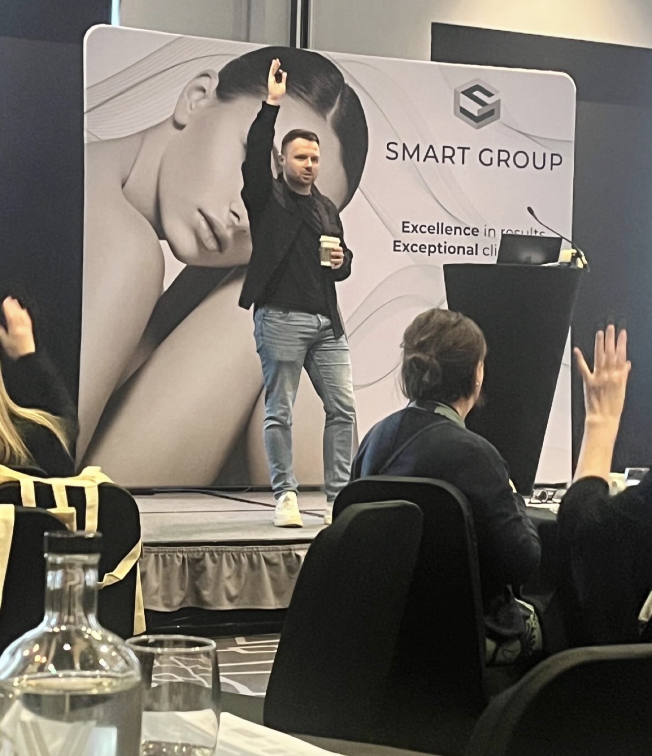 Chris Taylor speaking on stage at a business event